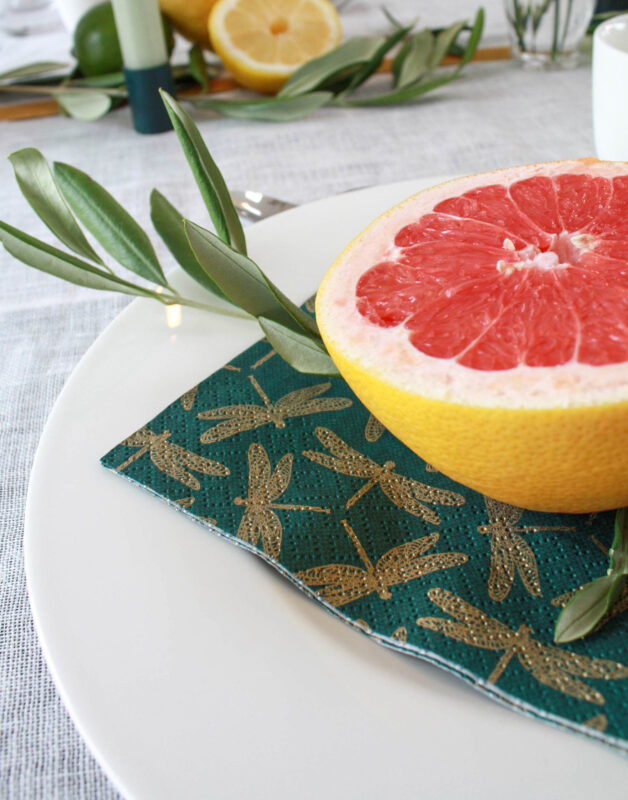 Brunch Tisch-Deko mit Grapefruit und Zitronen: Nahaufnahme Zitrusfrucht auf Olivenzweig